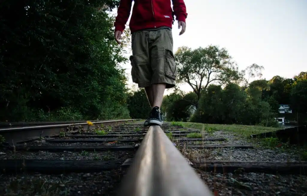 Kid walking on railroad