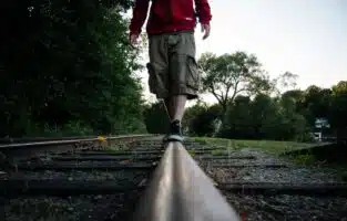 Kid walking on railroad
