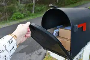 Opening a mailbox full of boxes packages delivered by the mailman USPS, generic brown box